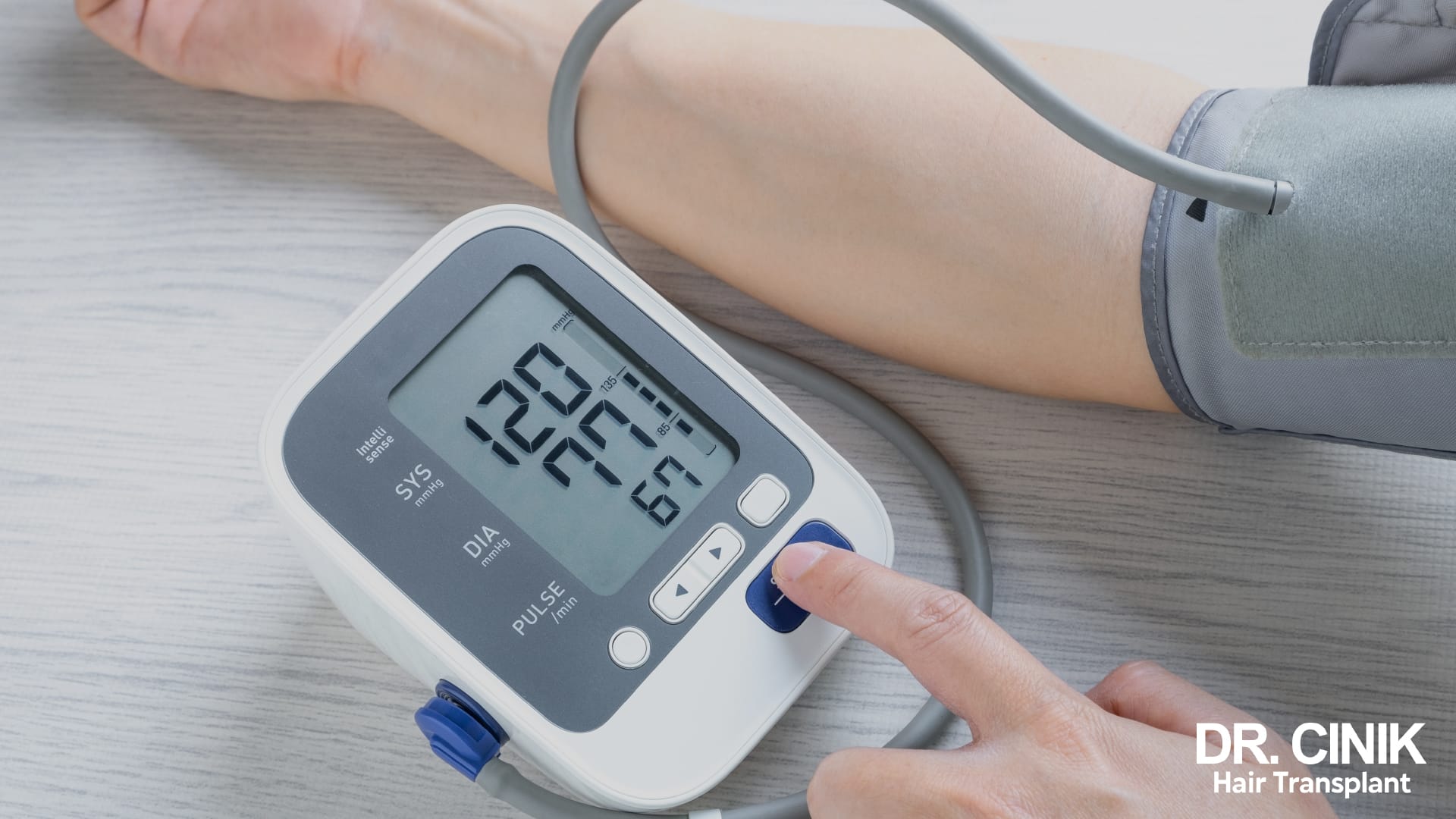 A practitioner takes a patient's blood pressure with an electronic cuff monitor