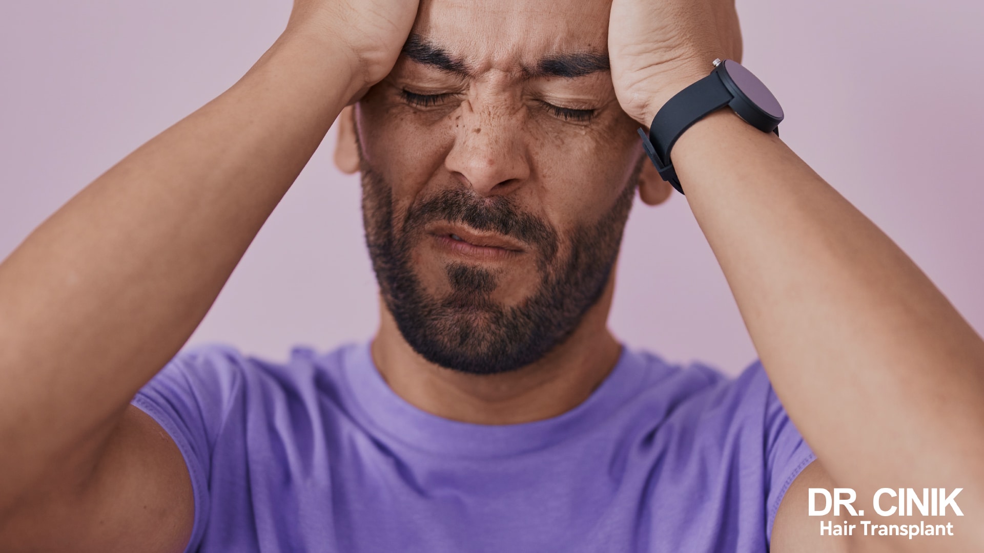 Man with his eyes closed holding his temples with both hands, the expression of a headache, purple background