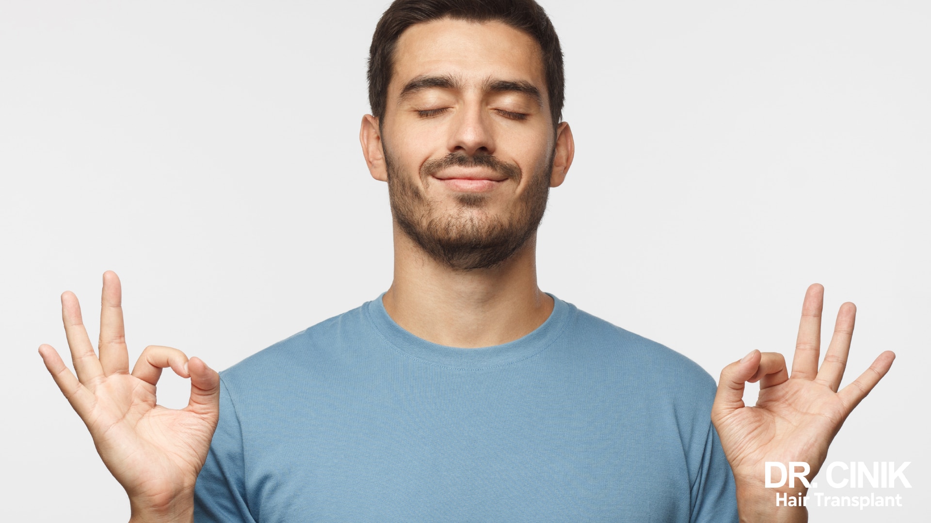 Man with his eyes closed in a meditation posture, hands open on either side of his face