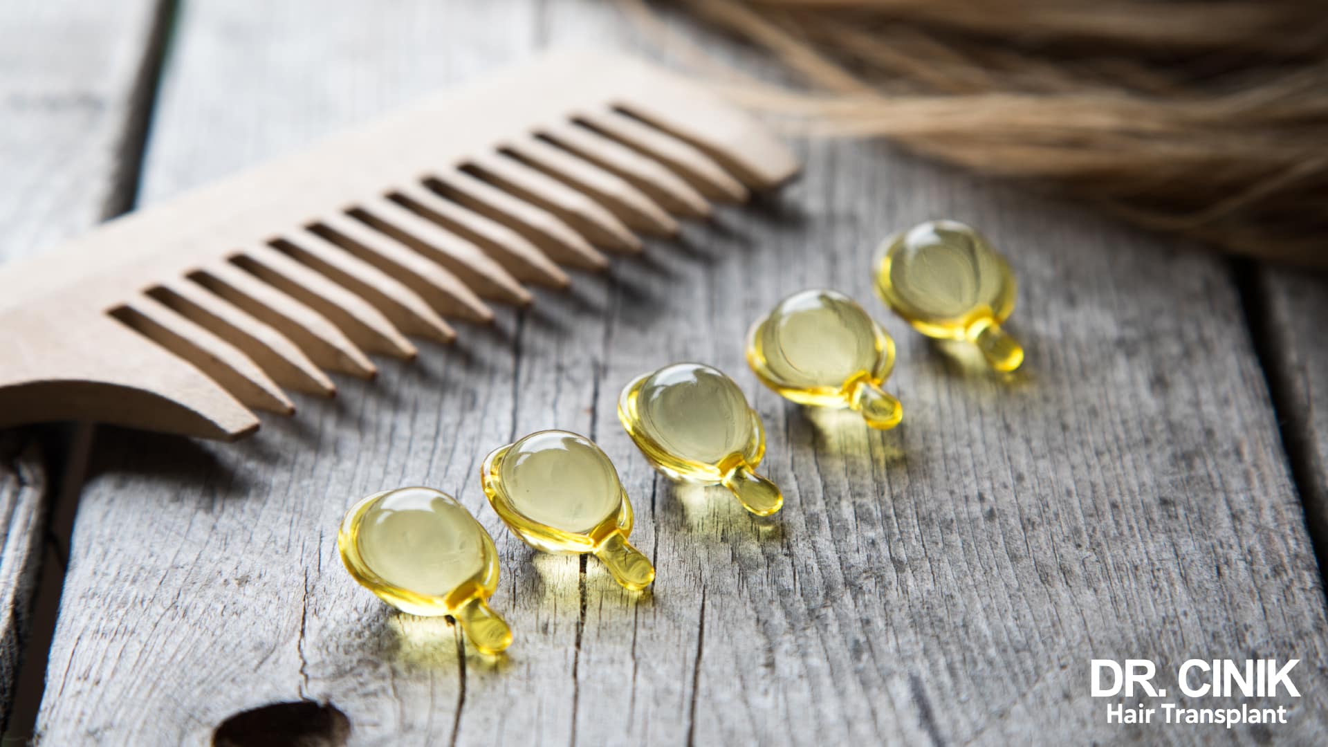 Oily food supplement capsules lying beside a wooden comb